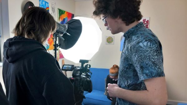 Behind the scenes of filming. Two young people are operating a camera.